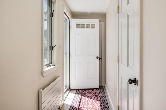 doorway with baseboards and radiator