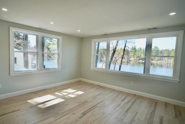 unfurnished room featuring baseboards, plenty of natural light, and light wood-style flooring