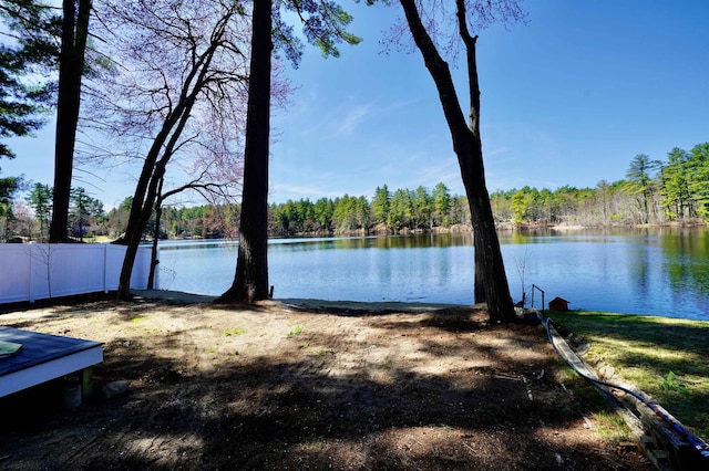 view of water feature featuring fence and a forest view