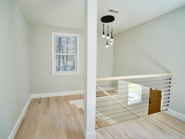 stairs featuring baseboards, wood finished floors, and visible vents