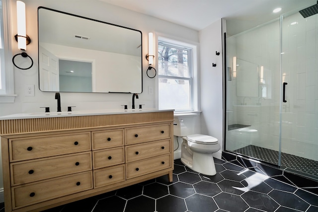full bath featuring double vanity, visible vents, a shower stall, a sink, and toilet
