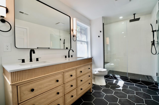 bathroom with toilet, visible vents, a shower stall, and a sink