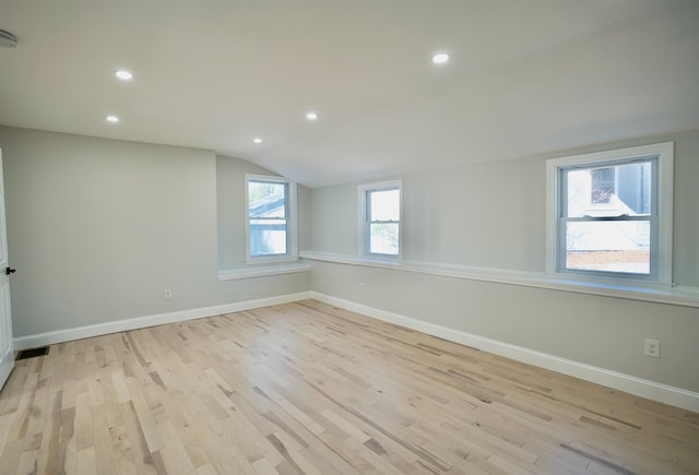 interior space featuring recessed lighting, baseboards, vaulted ceiling, and light wood-style floors