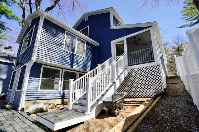 back of property with a ceiling fan, fence, stairway, and a deck