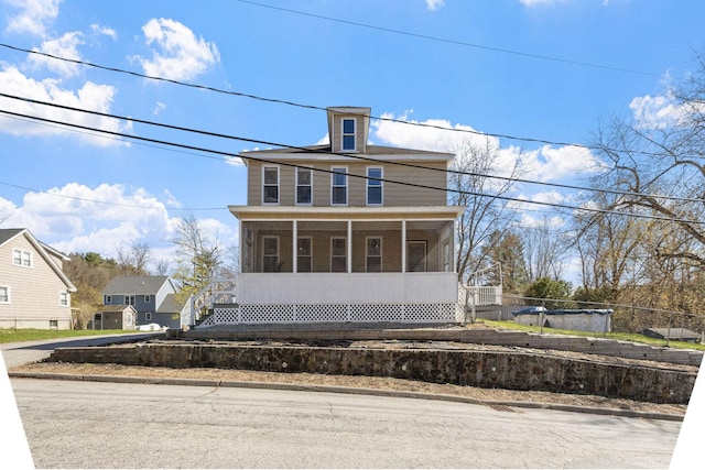 american foursquare style home featuring fence and a sunroom