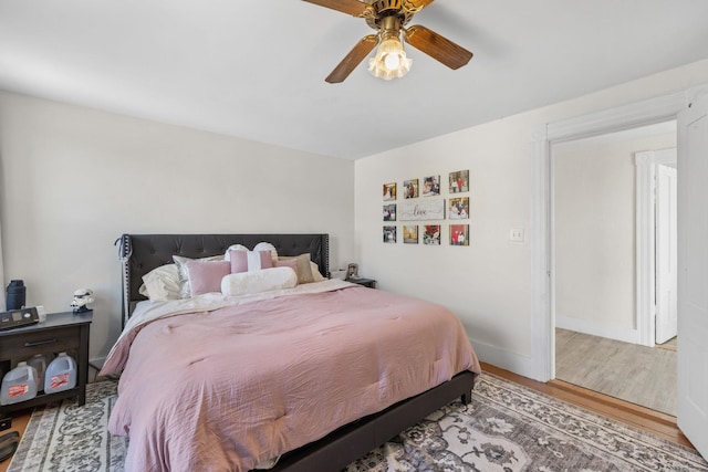 bedroom with baseboards, ceiling fan, and wood finished floors