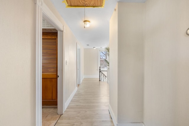 hallway with light wood-style floors and baseboards