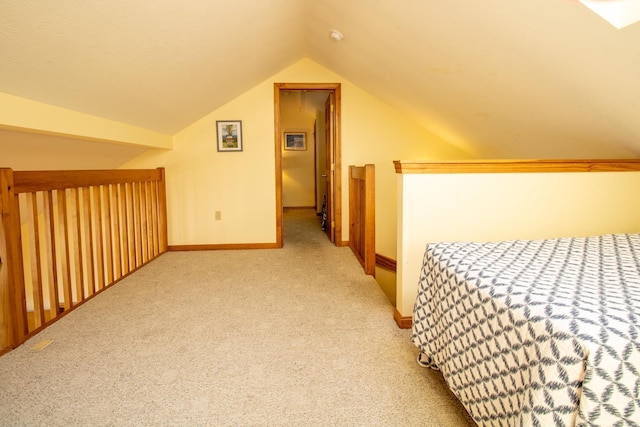 unfurnished bedroom with carpet floors, baseboards, and vaulted ceiling