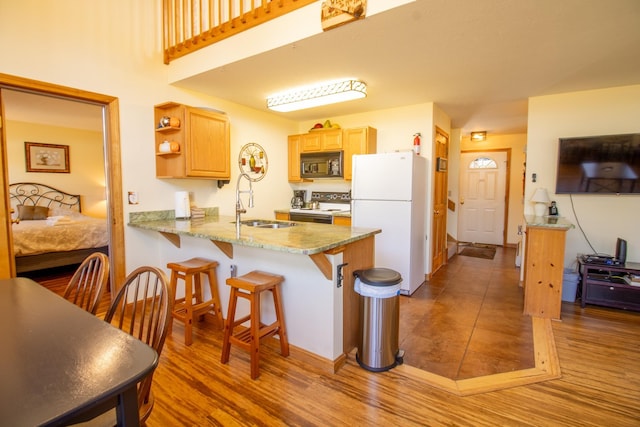 kitchen with a kitchen breakfast bar, open shelves, a sink, a peninsula, and white appliances