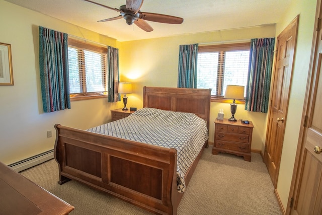 bedroom with baseboards, a baseboard heating unit, and light carpet