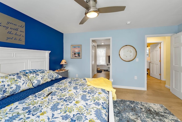 bedroom with baseboards, ceiling fan, ensuite bathroom, and light wood-style floors