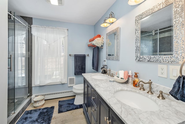 bathroom featuring a shower stall, a sink, and a baseboard radiator