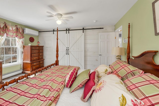 bedroom featuring ceiling fan, a barn door, baseboard heating, a wall mounted air conditioner, and carpet floors
