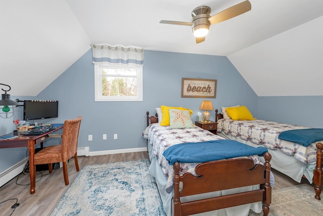 bedroom featuring ceiling fan, baseboard heating, baseboards, wood finished floors, and lofted ceiling
