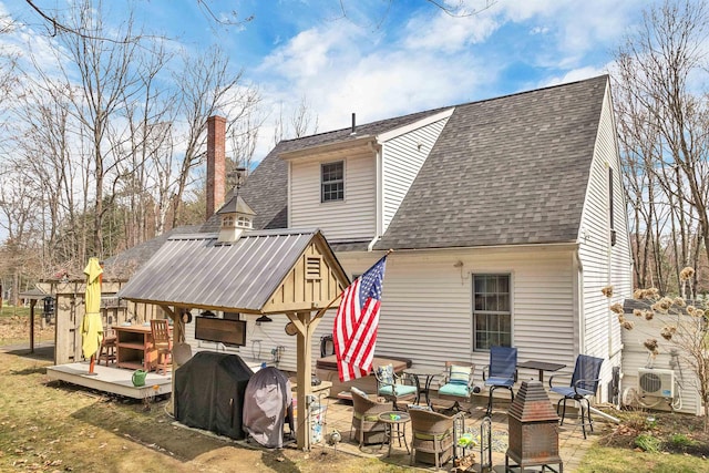 rear view of property with ac unit, a shingled roof, an outdoor hangout area, a wooden deck, and a chimney