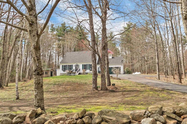 view of front facade featuring a front lawn and aphalt driveway