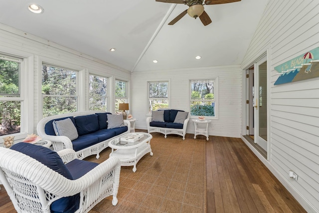 sunroom / solarium with a ceiling fan, vaulted ceiling, an outdoor hangout area, and hardwood / wood-style floors