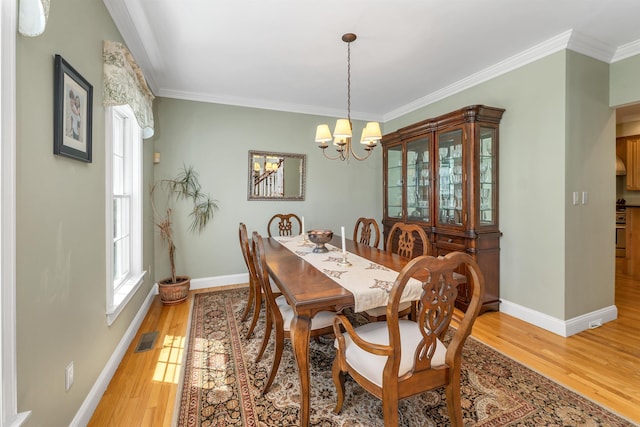 dining room with visible vents, ornamental molding, a healthy amount of sunlight, and light wood-style flooring
