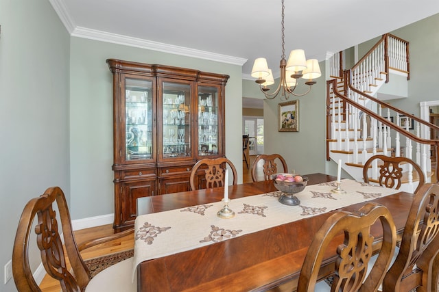 dining space featuring a notable chandelier, stairs, baseboards, wood finished floors, and ornamental molding