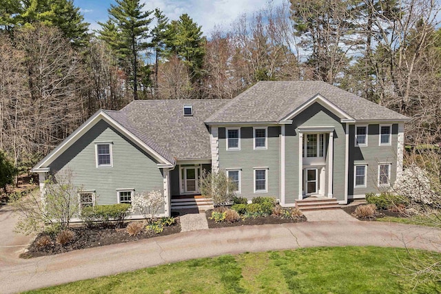 greek revival inspired property featuring roof with shingles