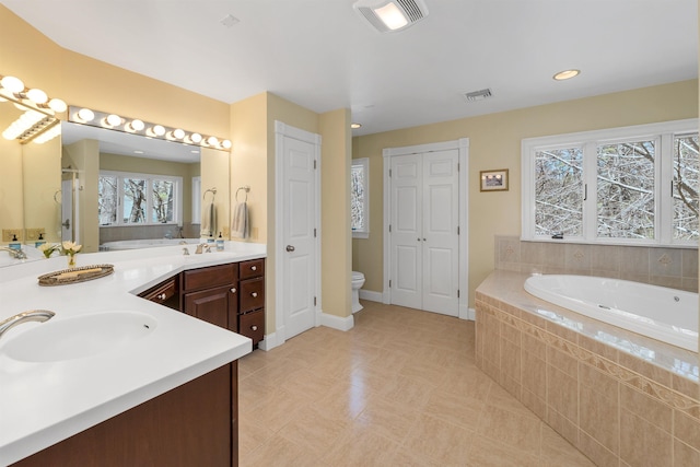 bathroom with visible vents, a healthy amount of sunlight, a bath, and a closet