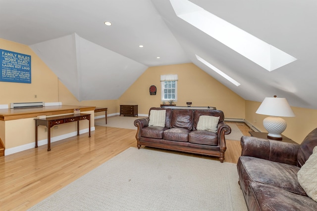 living area with wood finished floors, baseboards, recessed lighting, vaulted ceiling with skylight, and a baseboard radiator