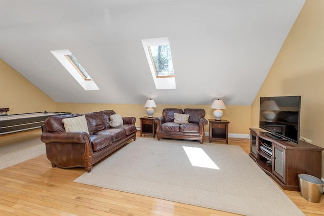 living area featuring wood finished floors and lofted ceiling with skylight