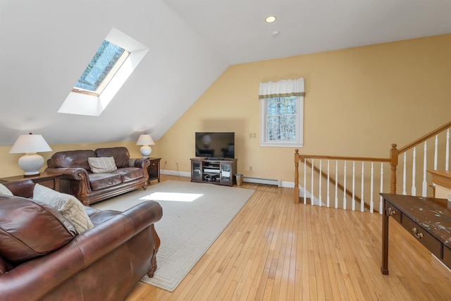 living room with baseboards, lofted ceiling with skylight, baseboard heating, and hardwood / wood-style flooring