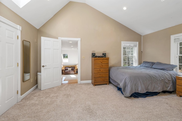 bedroom with light colored carpet, a skylight, high vaulted ceiling, baseboards, and recessed lighting