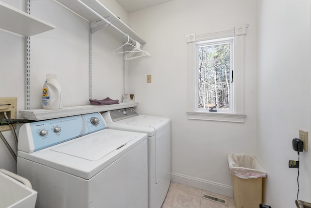 laundry room featuring laundry area, visible vents, washer and dryer, baseboards, and a sink