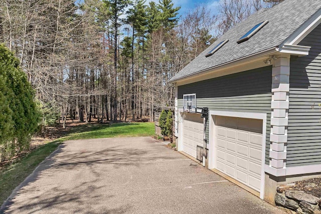 view of home's exterior featuring a garage and a shingled roof