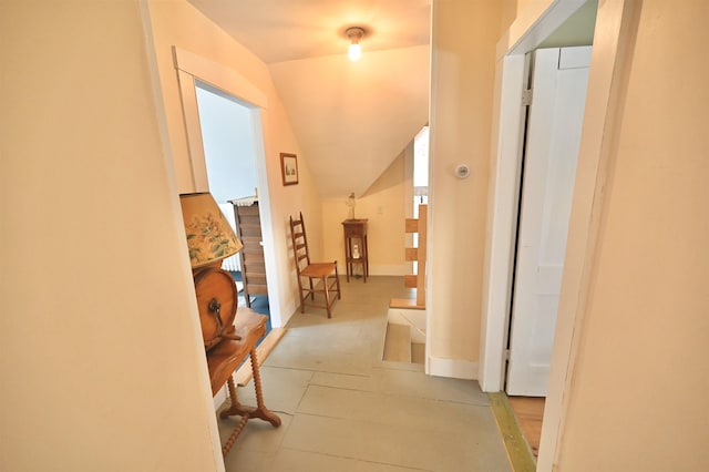 hall with baseboards and vaulted ceiling
