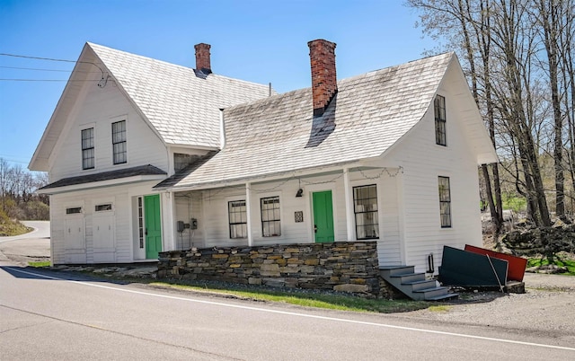 view of front of home with a porch and a chimney