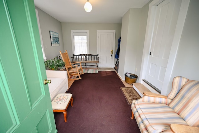 sitting room featuring baseboards and dark colored carpet