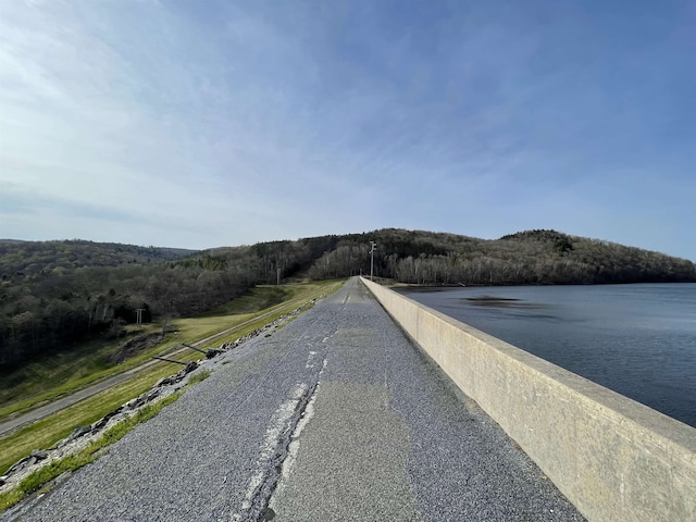 view of road featuring a water view and a wooded view