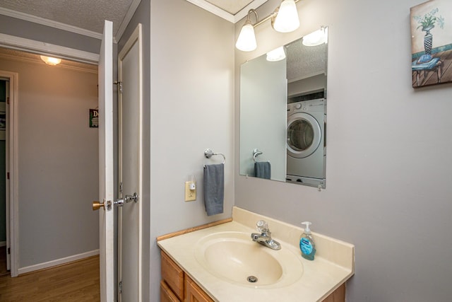 bathroom featuring vanity, crown molding, wood finished floors, washer / clothes dryer, and a textured ceiling