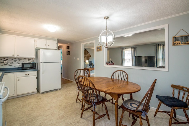 dining area featuring a textured ceiling, an inviting chandelier, and ornamental molding