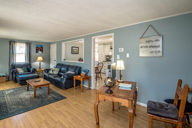 living area featuring ornamental molding, a textured ceiling, and wood finished floors