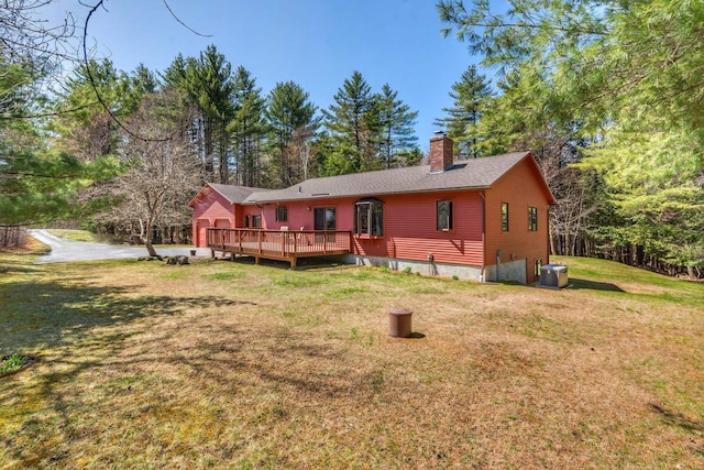 back of house with a yard, a deck, cooling unit, and a chimney