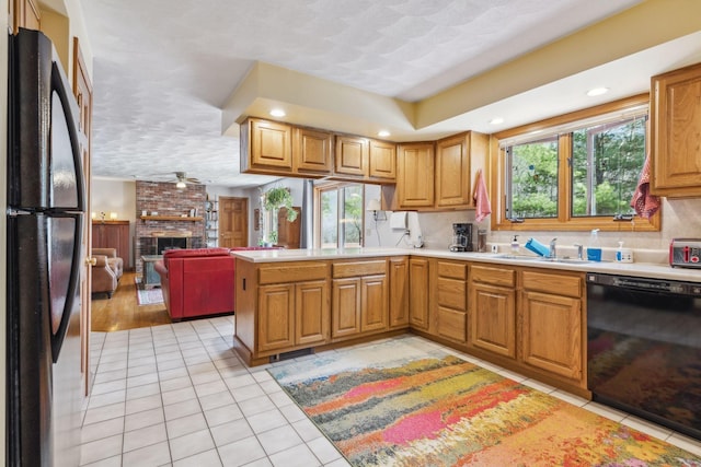 kitchen with light tile patterned floors, a healthy amount of sunlight, a sink, and black appliances