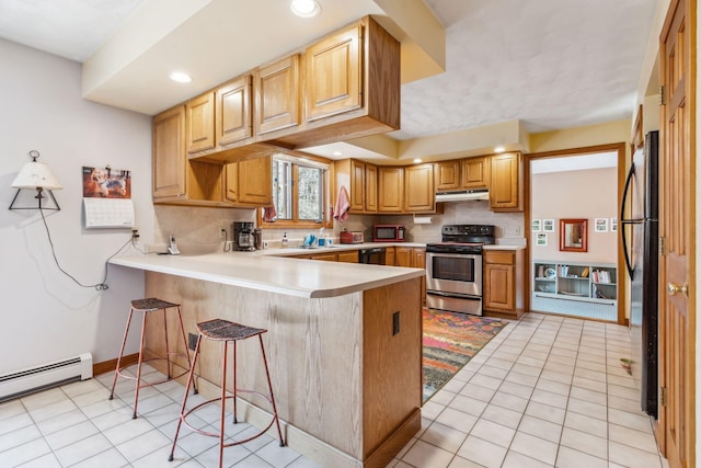 kitchen featuring decorative backsplash, black appliances, a peninsula, under cabinet range hood, and recessed lighting