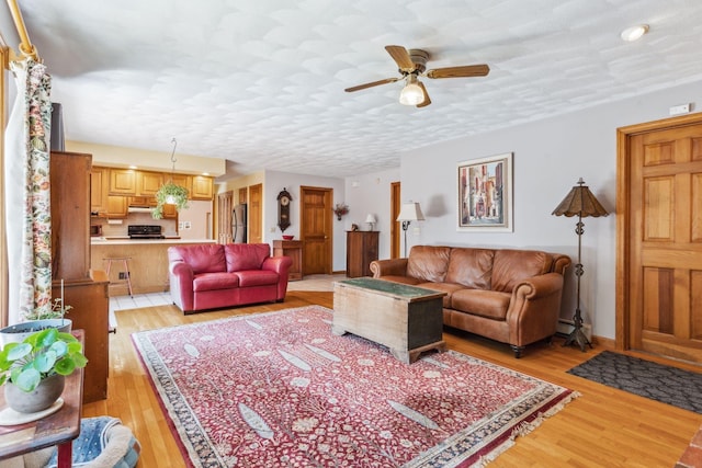 living area featuring ceiling fan and light wood-type flooring