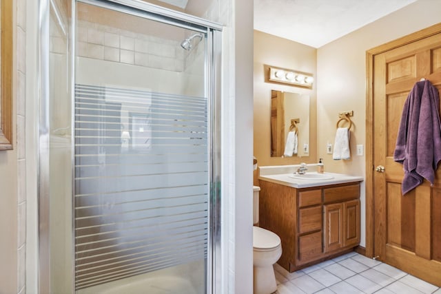 bathroom featuring vanity, tile patterned flooring, a stall shower, and toilet