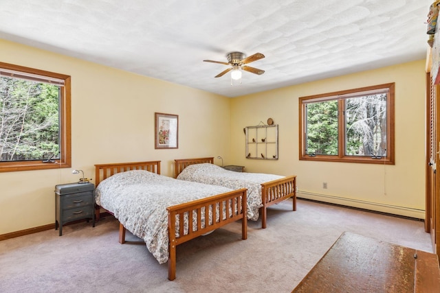 bedroom with carpet floors, baseboard heating, and multiple windows