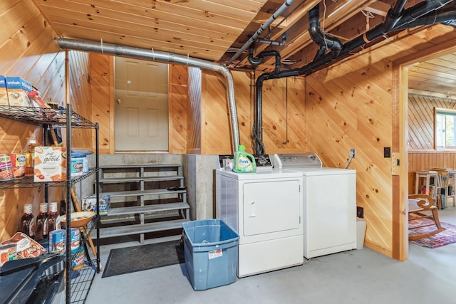 laundry area with laundry area, wooden walls, and washing machine and clothes dryer