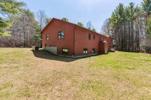 view of property exterior with a lawn and central AC unit