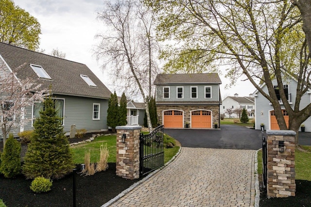 view of front facade with a garage, stone siding, and aphalt driveway