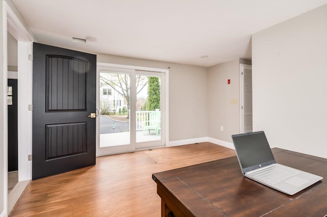 unfurnished office featuring baseboards and wood finished floors