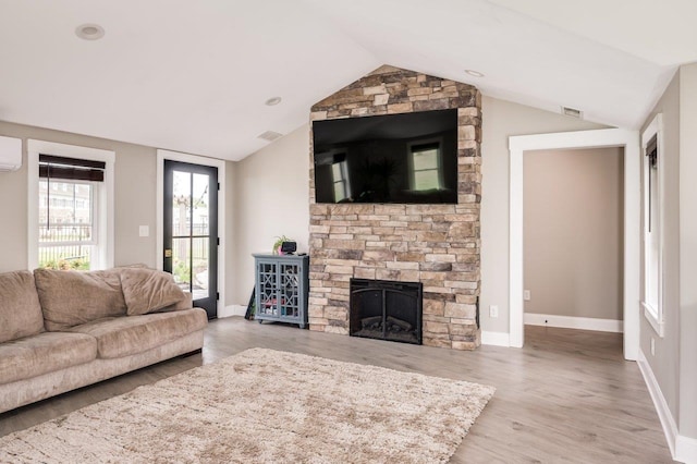 living room with a fireplace, baseboards, wood finished floors, lofted ceiling, and visible vents