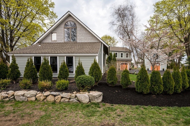 exterior space with a lawn and roof with shingles